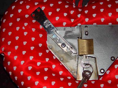 22. The knob at the end of the waistbelt now is fixed in an irrevocable way into the chosen slot of the groove of the locking block. The key can be taken out of the padlock now at the lower side