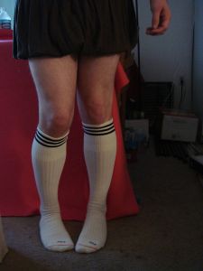 "Cute stance" of a man cross-dressed in a schoolgirl costume.