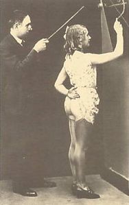 Teacher with blackboard pointer in c. 1930s spanking photo.